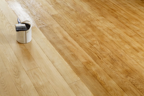 parquet en bois  en cours de rénovation avec pot contenant un produit de traitement du bois